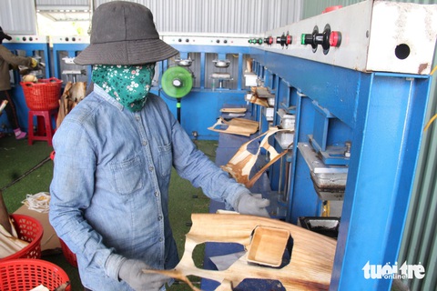 Công nhân dùng máy nén nhiệt độ cao để sản xuất các vật dụng từ mo cau Công nhân dùng máy nén nhiệt độ cao để sản xuất các vật dụng từ mo cau