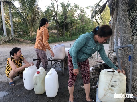 Độ mặn trên sông tăng cao, Tiền Giang mở 25 vòi nước công cộng cho bà con dùng miễn phí- Ảnh 4. Người dân các huyện phía đông tỉnh Tiền Giang dùng can nhựa hứng nước miễn phí tại các vòi công cộng dọc đường - Ảnh: HOÀI THƯƠNG