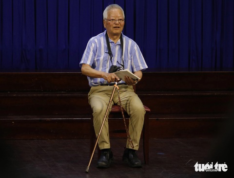 Gặp Ishikawa Bunyo - phóng viên chiến trường từng chụp ảnh ở cả hai miền Việt Nam thời chiến- Ảnh 2. Ông Ishikawa Bunyo năm nay đã 86 tuổi, chống gậy nhưng vẫn không quên cầm theo vật "bất ly thân" là chiếc máy ảnh - Ảnh: HỒ LAM