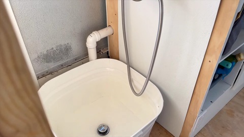 Kinh ngạc gia đình 9 người sống trên xe buýt- Ảnh 9. Sát đuôi xe là không gian dùng làm phòng tắm và phòng vệ sinh tách biệt làm 2 bên