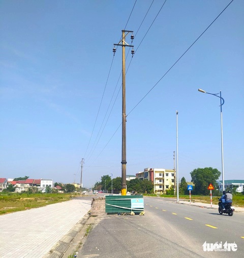 Cột điện 'đứng' giữa đường gây bất an cho người tham gia giao thông- Ảnh 2. Cột điện nằm ở lòng đường Lê Ninh chưa được di dời, tiềm ẩn nguy cơ mất an toàn - Ảnh: LÊ MINH