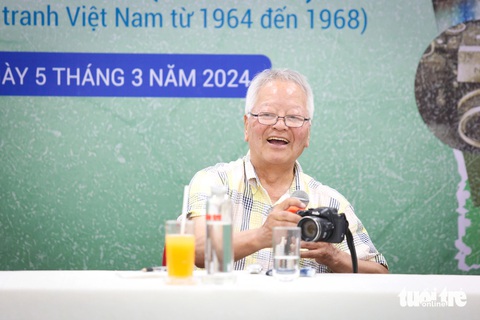 Phóng viên ảnh kỳ cựu Ishikawa Bun'yo: Nhà báo không có tuổi hưu- Ảnh 1. Nhà báo Ishikawa Bun'yo cầm máy tác nghiệp ngay giữa buổi giao lưu - Ảnh: PHƯƠNG QUYÊN