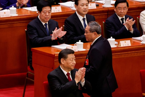 Trung Quốc đặt mục tiêu tăng trưởng GDP 5%, dễ hay khó?- Ảnh 3. Chủ tịch Trung Quốc Tập Cận Bình vỗ tay trong phiên khai mạc kỳ họp Đại hội đại biểu nhân dân toàn quốc (tức Quốc hội) Trung Quốc khóa 14 ngày 5-3. Còn Thủ tướng Lý Cường lên đọc báo cáo công tác - Ảnh: REUTERS
