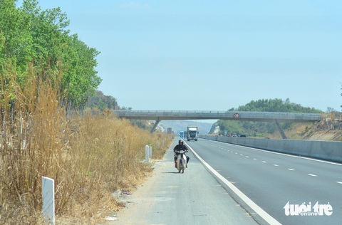 Đi bộ nhặt ve chai trên cao tốc Phan Thiết - Dầu Giây- Ảnh 3. Một người đàn ông chạy xe máy chui qua đoạn hàng rào dân sinh chưa hoàn thiện để đi vào cao tốc Phan Thiết - Dầu Giây, đoạn gần cột mốc Km48 bên phải tuyến.