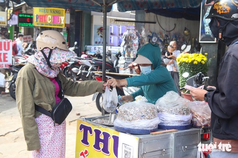 Giá lon ốc lể bằng 2 tô phở, người Đà Nẵng vẫn lùng mua- Ảnh 2. Khách hàng chờ đợi mua ốc trên đường Ông Ích Khiêm, Đà Nẵng - Ảnh: THANH NGUYÊN