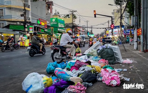 Đoạn đường Phan Văn Trị ở quận Bình Thạnh như bãi rác, nhiều người đến vứt bậy- Ảnh 1. Một người đàn ông chạy xe máy đến vứt rác xuống đường Phan Văn Trị (gần đường Nguyên Hồng, phường 11, quận Bình Thạnh) - Ảnh: CHÂU TUẤN