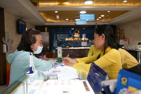 Giá vàng gần 82 triệu đồng: đứng ngoài thì tiếc, mua lại sợ 'đu đỉnh'- Ảnh 2. Nhân viên Công ty SJC hướng dẫn người dân điền vào phiếu mua vàng - Ảnh: PHƯƠNG QUYÊN