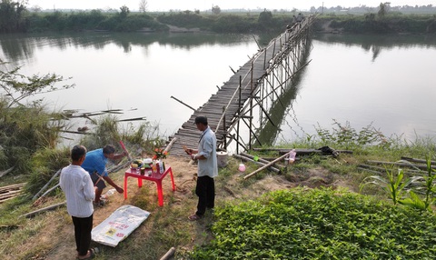 Người dân đu mình cắm sào nối cầu Nghi thức cúng của người dân địa phương khi cầu đã nối đôi bờ