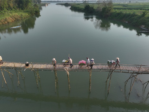 Người dân đu mình cắm sào nối cầu Người dân chở nông sản qua sông sau khi cầu hoàn thành