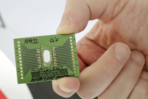 A sample of tellurite glass with laser-inscribed circuits mounted on an energy-harvesting device. Researchers hope that the new technology may pave the way for clean energy in the future. | KYODO Một mẩu thủy tinh tellurite được khắc laser femtosecond (laser phát ra xung ánh sáng siêu ngắn) có thể tạo ra dòng điện - Ảnh: KYODO