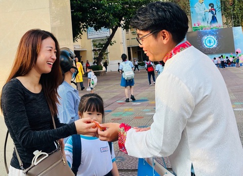 Đưa con đi học, mẹ bất ngờ nhận được quà 8-3- Ảnh 1. Giáo viên Trường tiểu học Trần Hưng Đạo, quận 1, TP.HCM chúc mừng và tặng quà 8-3 cho phụ huynh
