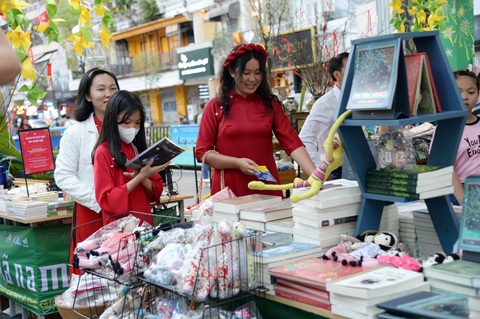 Áo dài mang cả niềm tự hào- Ảnh 4. Nhiều chị em chọn áo dài xuống phố du xuân, dạo đường sách dịp Tết vừa qua - Ảnh: TỰ TRUNG