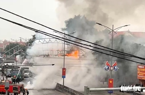 Cổng chào thị trấn giữa quốc lộ cháy ngùn ngụt- Ảnh 3. Lực lượng cảnh sát phòng cháy chữa cháy có mặt dập tắt đám cháy - Ảnh: TÂM PHẠM
