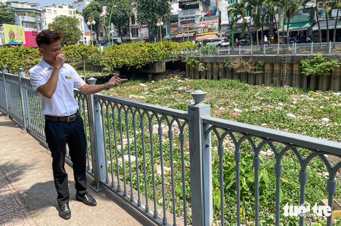 Kênh Nhiêu Lộc - Thị Nghè 1 tháng chưa dọn, ngộp thở với 'biển rác' trên sông- Ảnh 5. Chỉ tay về hướng rác đang ứ đọng, anh Mai Thành Liêm nói với phóng viên: "Cả tháng rồi mà kênh này không được dọn nên bốc mùi kinh khủng. Tôi mong đơn vị môi trường sớm thu gom sạch sẽ để cuộc sống người dân không bị ảnh hưởng" - Ảnh: CHÂU TUẤN