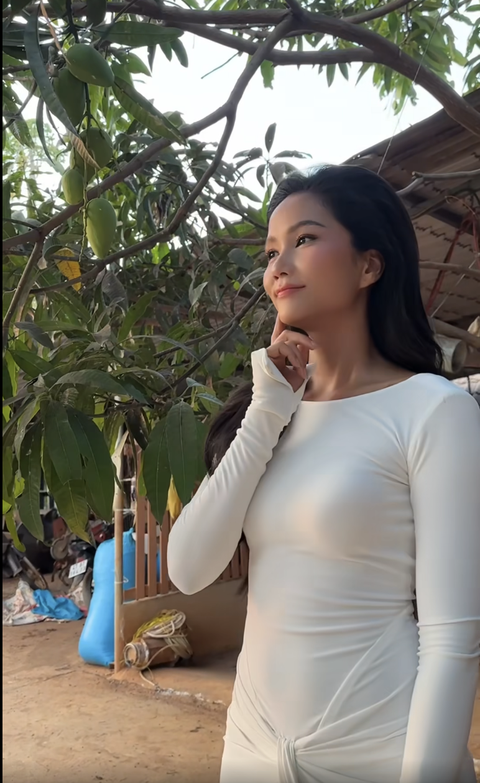H'Hen Niê 'tấu hài' cực mạnh với màn mặc đầm dạ hội đi cào tiêu- Ảnh 3. Nàng hậu hồn nhiên trò chuyện cùng trái xoài trên cây và
