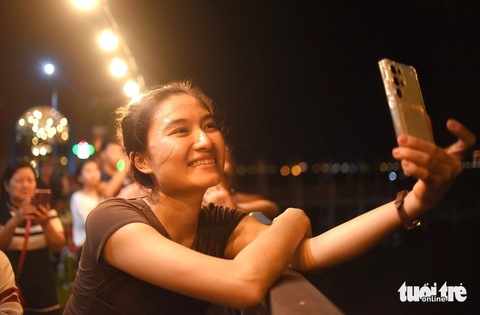 Một bạn trẻ thích thú, say sưa ngắm màn trình diễn pháo hoa và Drone - Ảnh: LÂM THIÊN Một bạn trẻ thích thú ghi hình màn trình diễn pháo hoa và drone - Ảnh: LÂM THIÊN