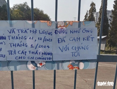 Hàng chục công nhân may ngưng việc đi đòi lương, bảo hiểm, trợ cấp- Ảnh 4. Những người này dán bảng trước cổng công ty để đòi lương và bảo hiểm - Ảnh: ĐOÀN NHẠN