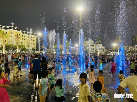 Trẻ em ùa vào tắm ở sàn nhạc nước quảng trường 29-3 Đà Nẵng gây tranh cãi- Ảnh 2. Nhiều phụ huynh chia sẻ không thể cản nổi trẻ nhỏ nên đành để cho các bé vui chơi - Ảnh: SANG NGUYEN