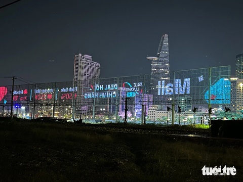 Màn hình sky LED được quảng bá là lớn và hiện đại. Khi nhìn hướng ngược lại hoặc khi tắt đèn, vẫn thấy được quang cảnh phía sau. Ảnh chụp hướng từ Thủ Thiêm (TP Thủ Đức) nhìn về trung tâm TP.HCM - Ảnh: T.T.D. Màn hình sky LED được quảng bá là lớn và hiện đại có màn hình làm bằng lưới. Khi nhìn hướng ngược lại hoặc khi tắt đèn vẫn thấy được quang cảnh phía sau. Ảnh chụp hướng từ Thủ Thiêm (TP Thủ Đức) nhìn về trung tâm TP.HCM - Ảnh: T.T.D.
