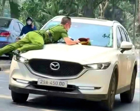 Ô tô húc cảnh sát lên nắp ca pô: Tài xế dương tính ma túy- Ảnh 1. Cảnh sát nằm bám trên nắp ca pô chiếc ô tô - Ảnh: H.A.