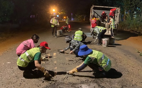 Dưới ánh đèn đường, các bạn trẻ đội tình nguyện vá đường ở phố núi lại cùng nhau làm việc có ích cho đời - Ảnh: TUẤN THÀNH Dưới ánh đèn đường, các bạn trẻ đội tình nguyện vá đường ở phố núi lại cùng nhau làm việc có ích cho đời - Ảnh: TUẤN THÀNH