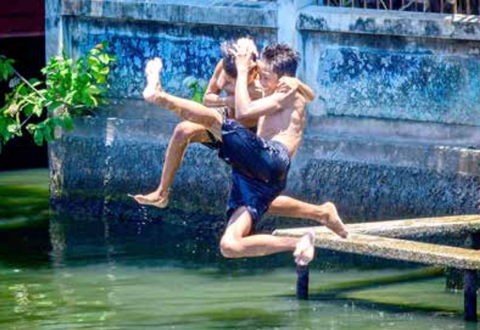 Hai đứa trẻ nhảy xuống một con kênh để giải nhiệt ở thủ đô Bangkok (Thái Lan) - Ảnh: AFP Hai đứa trẻ nhảy xuống một con kênh để giải nhiệt ở thủ đô Bangkok (Thái Lan) - Ảnh: AFP