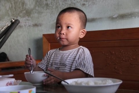 Cậu bé Việt mang trong mình lá gan người Ý- Ảnh 3. Lộc từ cậu bé yếu ớt sinh mệnh tính tháng, đếm ngày, sau khi nhận lá gan của một người Ý hiến tặng đã khỏe mạnh, giờ cậu bé có thể tự múc cơm ăn - Ảnh: TRẦN MAI