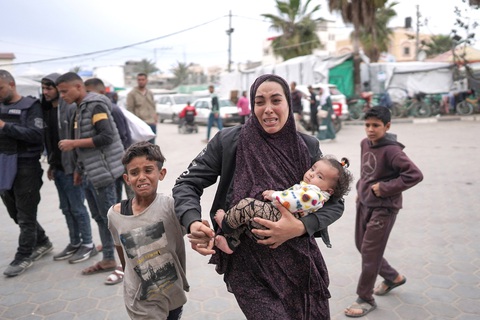 Mong manh hy vọng ngừng bắn ở Gaza- Ảnh 1. Một gia đình Palestine chạy đến bệnh viện sau một cuộc không kích ở miền trung Dải Gaza ngày 8-4 - Ảnh: AFP
