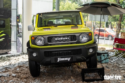 Suzuki Jimny ra mắt Việt Nam, giá từ 799 triệu đồng- Ảnh 3. Suzuki Jimny thu hút sự chú ý đặc biệt của các hội nhóm chơi off-road và cắm trại. Thiết kế mang đậm phong cách retro hình hộp gợi nhớ đến các mẫu xe Land Rover Defender hay Mercedes-Benz G-Class. Trong sự kiện ra mắt xe, đại lý còn đặt chiếc Jimny trên nền gạch đá cùng một vài món phụ kiện dã ngoại như ghế, thùng đồ hay ô...