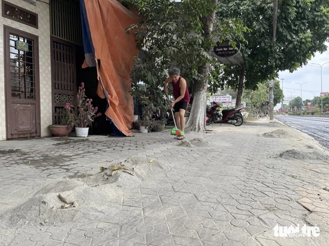 Thi công đường thổi bụi mù mịt, dân phát khóc vì dọn nhà từ sáng đến trưa- Ảnh 2. Chỉ sau một đêm, cuộc sống của người dân trên đường Nguyễn Trãi bị đảo lộn, họ phải quét lại lượng đất, bụi bám từ nhà ra tận vỉa hè - Ảnh: TRẦN MAI