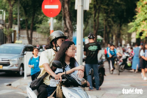 Mặc dù con có chiều cao gần vượt qua tầm nhìn của người bố tuy nhiên phụ huynh vẫn cho con ngồi đằng trước tay lái của mình và cũng chẳng đội nón bảo hiểm - Ảnh: THANH HIỆP Mặc dù con có chiều cao gần vượt qua tầm nhìn của người bố nhưng phụ huynh vẫn cho con ngồi đằng trước tay lái của mình và cũng chẳng đội mũ bảo hiểm - Ảnh: THANH HIỆP
