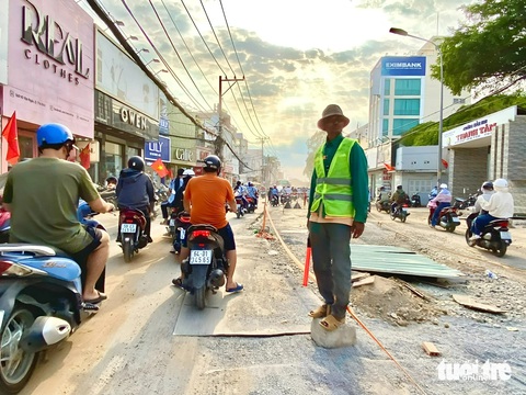 Tháo dỡ lô cốt bóp nghẹt đường Võ Văn Ngân, giảm tình trạng kẹt xe- Ảnh 3. Trong quá trình tháo dỡ, đơn vị thi công đã bố trí người điều phối giao thông - Ảnh: TIẾN QUỐC