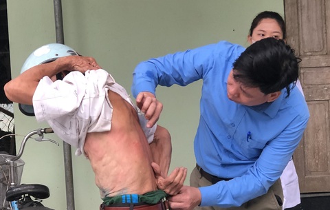 Hàng loạt người dân ở Thanh Hóa bị ngứa ngoài da kéo dài chưa rõ nguyên nhân- Ảnh 1. Cán bộ y tế kiểm tra vùng ngứa ngoài da cho một người dân ở xã Vĩnh Hòa, huyện Vĩnh Lộc - Ảnh: Trung tâm Kiểm soát bệnh tật tỉnh Thanh Hóa cung cấp