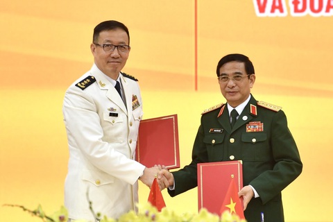 Hội đàm giữa Bộ Quốc phòng hai nước Việt Nam - Trung Quốc: 'Trên biển cần giải quyết bằng hòa bình'- Ảnh 1. Đại tướng Phan Văn Giang - bộ trưởng Bộ Quốc phòng Việt Nam (bên phải) và Thượng tướng Đổng Quân - bộ trưởng Bộ Quốc phòng Trung Quốc (bên trái) thực hiện ký kết bản ghi nhớ về thiết lập đường dây nóng giữa Quân chủng hải quân - Bộ Quốc phòng Việt Nam và Chiến khu miền Nam - Quân giải phóng nhân dân Trung Quốc tại hội đàm - Ảnh: TRỌNG HẢI