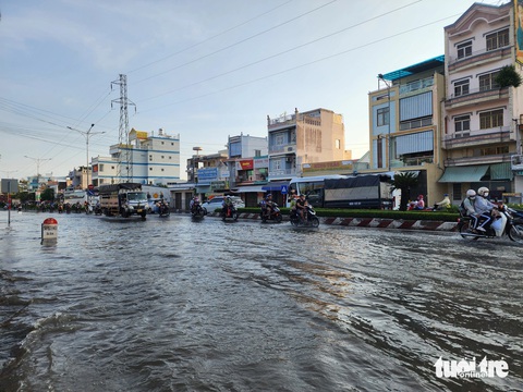 Triều cường lại gây ngập ở Mỹ Tho, nhân viên nhà hàng bơi xuồng đi lại- Ảnh 3. Tại khu vực ngã ba Trung Lương, triều cường gây ngập khiến xe cộ qua đây gặp nhiều khó khăn - Ảnh: HOÀI THƯƠNG