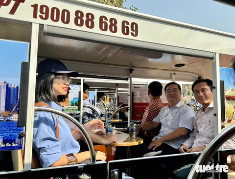 Tài xế mặc áo bà ba, lái xe điện chở khách dạo trung tâm TP.HCM- Ảnh 3. Người dân hào hứng đi thử xe điện dạo trung tâm TP.HCM - Ảnh: THU DUNG