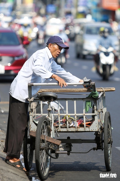 Nắng nóng đỉnh điểm, người dân TP.HCM vất vả mưu sinh- Ảnh 5. Ông Nam (65 tuổi) xếp hàng chuẩn bị đi giao cho khách lúc 11h trưa. Ảnh chụp trên đường Bạch Đằng (quận Bình Thạnh) - Ảnh: PHƯƠNG QUYÊN