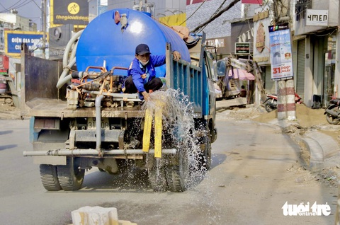Nắng nóng đỉnh điểm, người dân TP.HCM vất vả mưu sinh- Ảnh 12. Đơn vị thi công tưới nước bề mặt đường Võ Văn Ngân nhằm giảm tình trạng cát bụi bay - Ảnh: TIẾN QUỐC