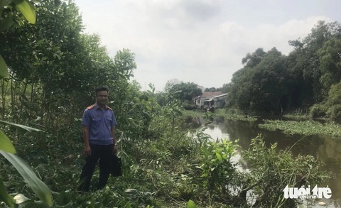 Phạm nhân trốn khỏi trại giam Mỹ Phước để về thăm bà ngoại già- Ảnh 2. Cơ quan tố tụng đang khám nghiệm hiện trường nơi con sông phạm nhân đã bỏ trốn - Ảnh: HOÀI THƯƠNG