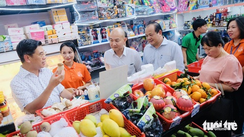 Phó chủ tịch UBND TP.HCM thăm 'tạp hóa giá tốt', gợi ý hiện đại hóa- Ảnh 2. Khi biết các chủ tiệm tạp hóa có nhu cầu vay vốn, ông Nguyễn Văn Dũng - phó chủ tịch UBND TP.HCM (bìa trái) gợi ý tìm hiểu về gói vay đối với hộ gia đình, nhằm phát triển hoạt động sản xuất và kinh doanh - Ảnh: BÔNG MAI