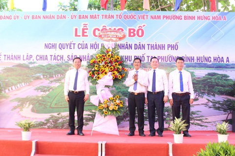 Phường đông dân nhất TP.HCM tăng gấp đôi khu phố sau sắp xếp- Ảnh 1. Bí thư quận Bình Tân (bìa trái) trao hoa chúc mừng lãnh đạo phường Bình Hưng Hòa A - Ảnh: L.T.