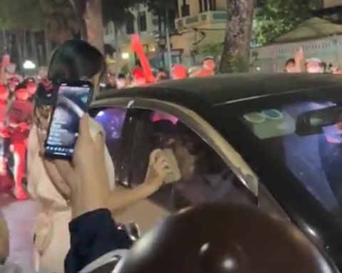 Người phụ nữ nghi đánh ghen, dùng gạch đập ô tô trên phố Hà Nội- Ảnh 1. Người phụ nữ dùng gạch đập liên tiếp vào ô tô - Ảnh: H.T.