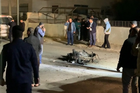 An image grab from AFPTV footage shows Jordanian onlookers and security agents standing around the debris of a missile that the Jordanian forces intercepted over Amman amid an unprecedented Iranian drone and missile attack on Israel in the early hours of April 14, 2024 Người dân và lực lượng an ninh đứng xung quanh mảnh vỡ của một tên lửa mà lực lượng Jordan đã đánh chặn trên bầu trời thủ đô Amman (Jordan), trong bối cảnh Iran tấn công Israel bằng tên lửa và drone vào rạng sáng 14-4 - Ảnh: AFP