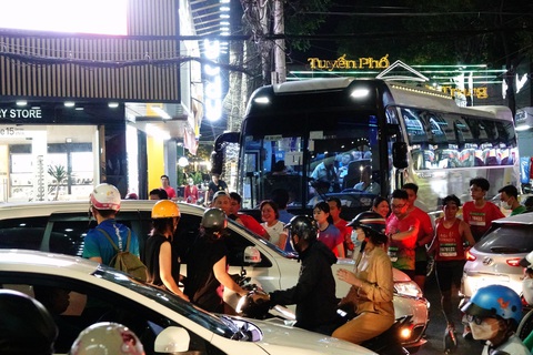 Vận động viên xanh mặt len lỏi qua dòng ô tô, xe máy tại giải marathon Cần Thơ- Ảnh 1. Các vận động viên trong vòng vây xe cộ tại Giải chạy bộ đêm âm nhạc ở Cần Thơ - Ảnh: B.K.