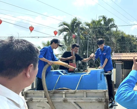 Trời nóng bức, hiệu trưởng đại học vận động tặng cả trăm khối nước sạch cho bà con- Ảnh 5. Lực lượng thanh niên địa phương hỗ trợ chuyển nước từ xe bồn xuống cho người dân - Ảnh: THẢO CHI