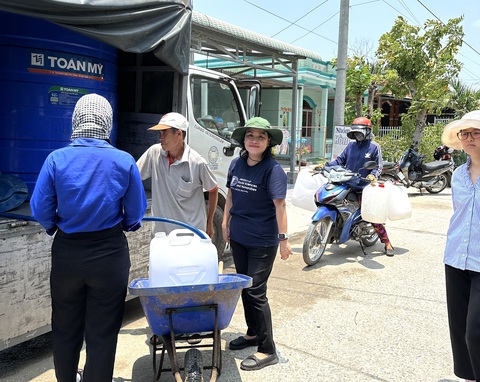Trời nóng bức, hiệu trưởng đại học vận động tặng cả trăm khối nước sạch cho bà con- Ảnh 1. Bà Ngô Thị Phương Lan, hiệu trưởng Trường đại học Khoa học xã hội và Nhân văn TP.HCM (giữa), tham gia phân phối nước cho bà con Long An sáng 14-4 - Ảnh: THẢO CHI