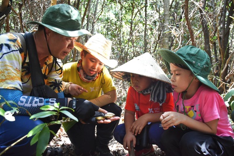 Đón bình minh sớm nhất ở Mũi Đôi cực đông đất liền bằng đường bộ- Ảnh 5. Các em nhỏ được hướng dẫn sử dụng la bàn khi đi trong rừng - Ảnh: TRẦN HOÀI