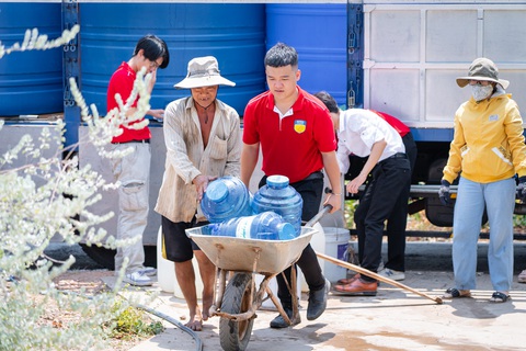 Sinh viên kêu gọi tài trợ, đưa nước sạch về cho người dân vùng hạn mặn- Ảnh 1. Các bạn sinh viên hỗ trợ mang nước sạch về tận nhà cho bà con vùng hạn mặn tỉnh Tiền Giang - Ảnh: NVCC