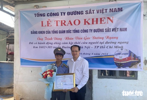 Tổng công ty Đường sắt tặng bằng khen cho nhân viên gác chắn cứu người trong 4 giây- Ảnh 1. Ông Trần Anh Tuấn - phó tổng giám đốc Tổng công ty Đường sắt Việt Nam - trao bằng khen cho ông Trịnh Dũng - Ảnh: Công ty cổ phần Đường sắt Sài Gòn