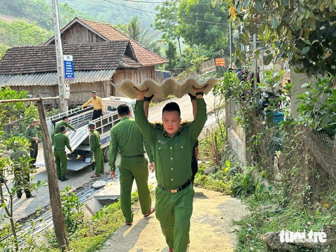 Công an đội nắng giúp dân sửa nhà sau mưa đá, dông lốc- Ảnh 2. Các chiến sĩ công an bốc vác từng mái ngói lên để lợp lại nhà cho người dân - Ảnh: TÂM PHẠM